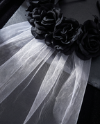 Detail of faux black roses and mesh veil