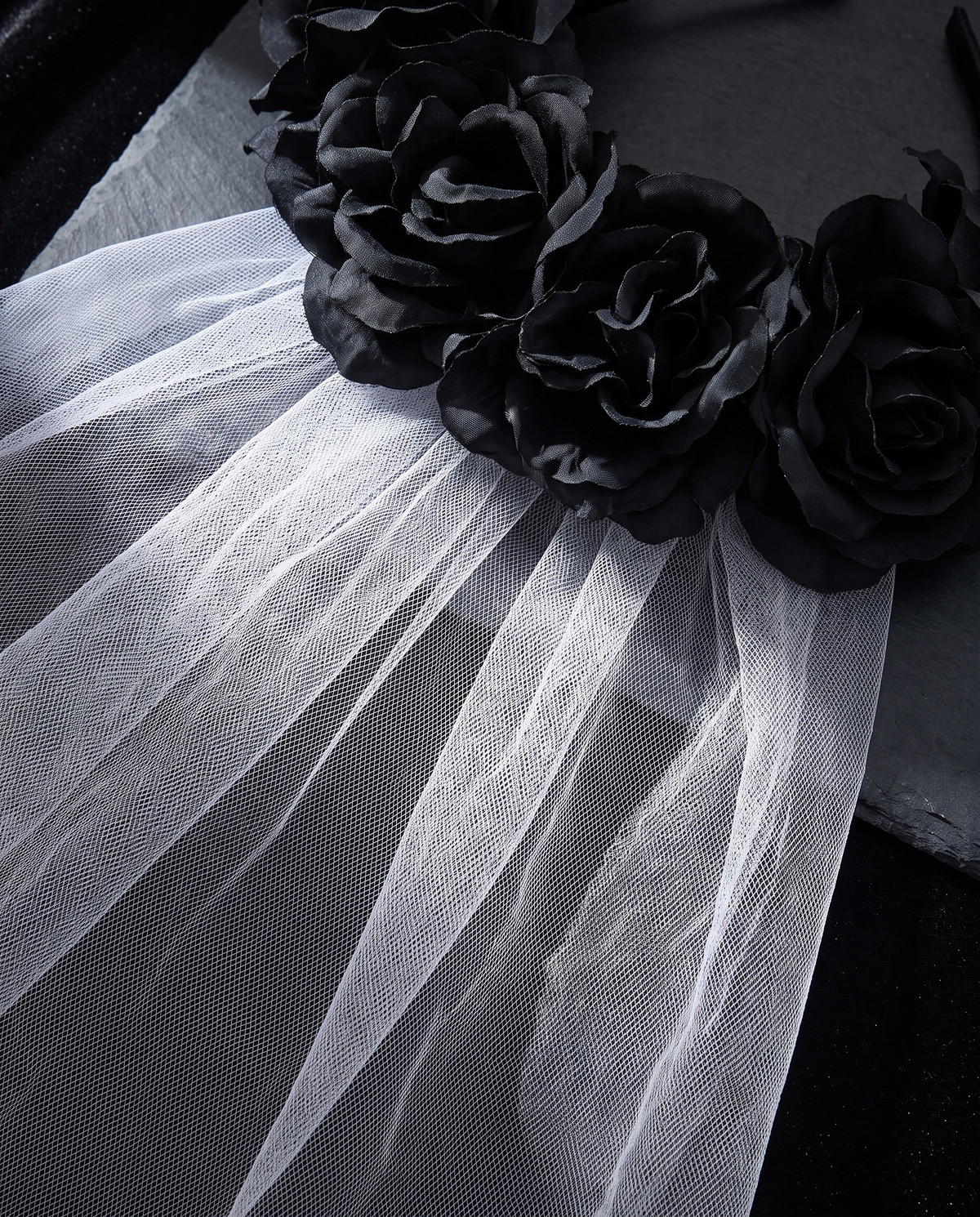 Detail of faux black roses and mesh veil