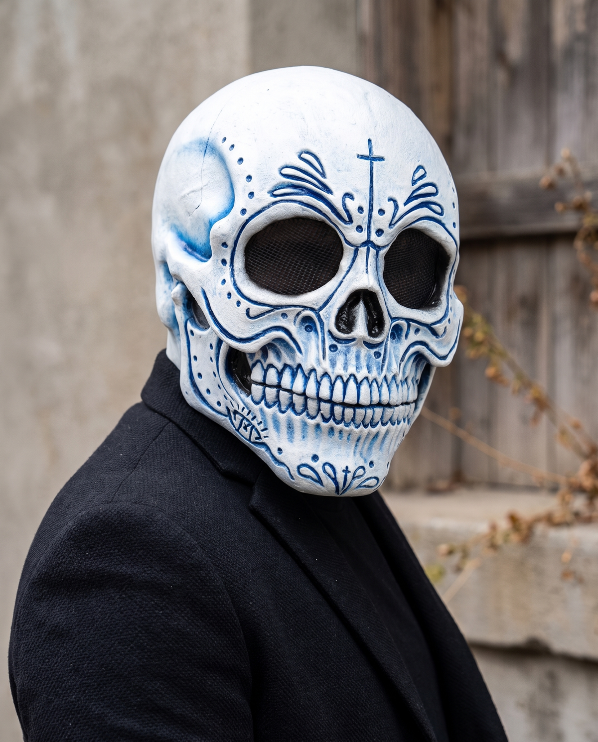 Person wearing blue Catrina skull latex mask