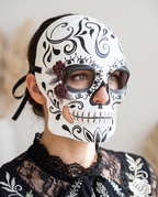 Woman wearing black and white sugar skull half mask