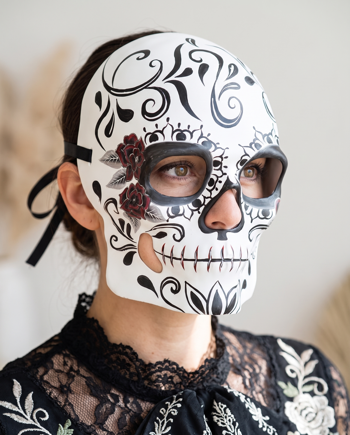 Woman wearing black and white sugar skull half mask