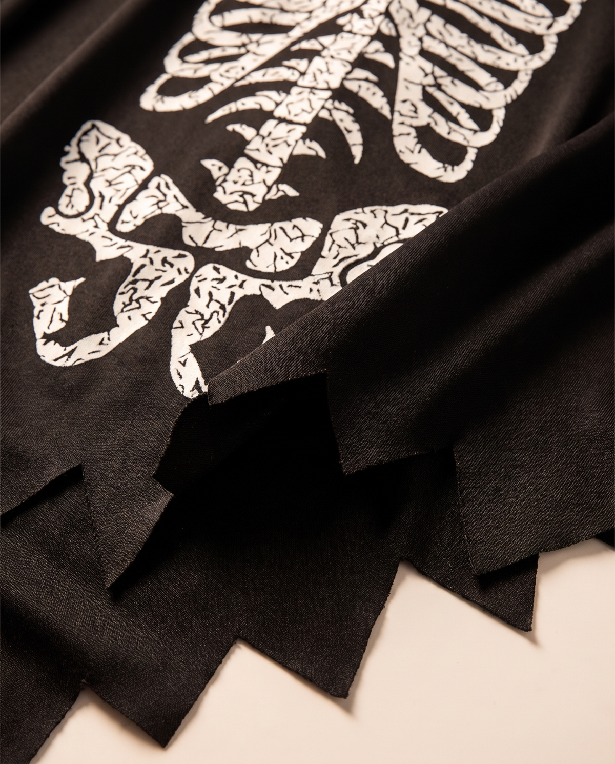 Detail of white skeleton print and jagged hem