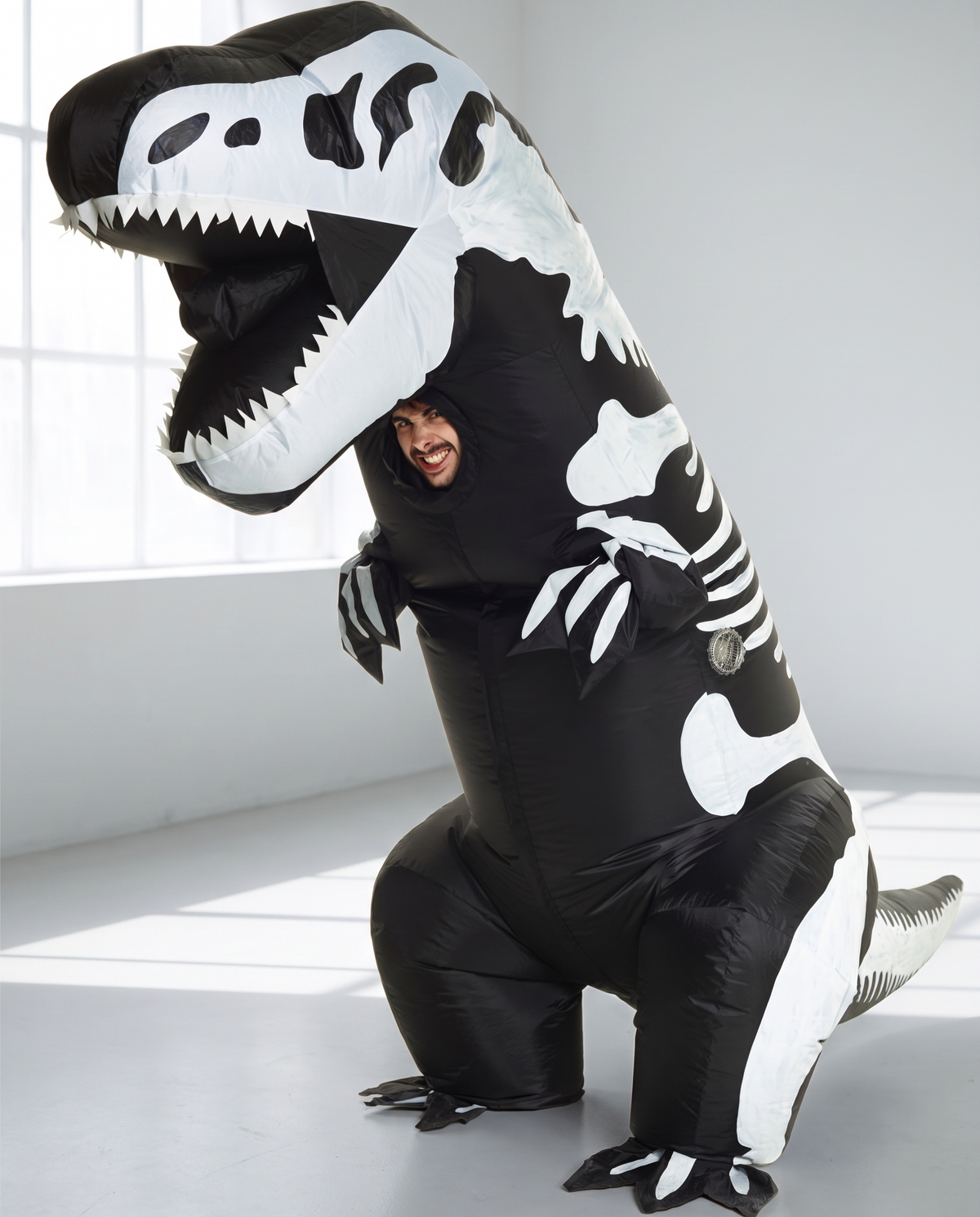 Person wearing giant inflatable skeleton T-rex costume