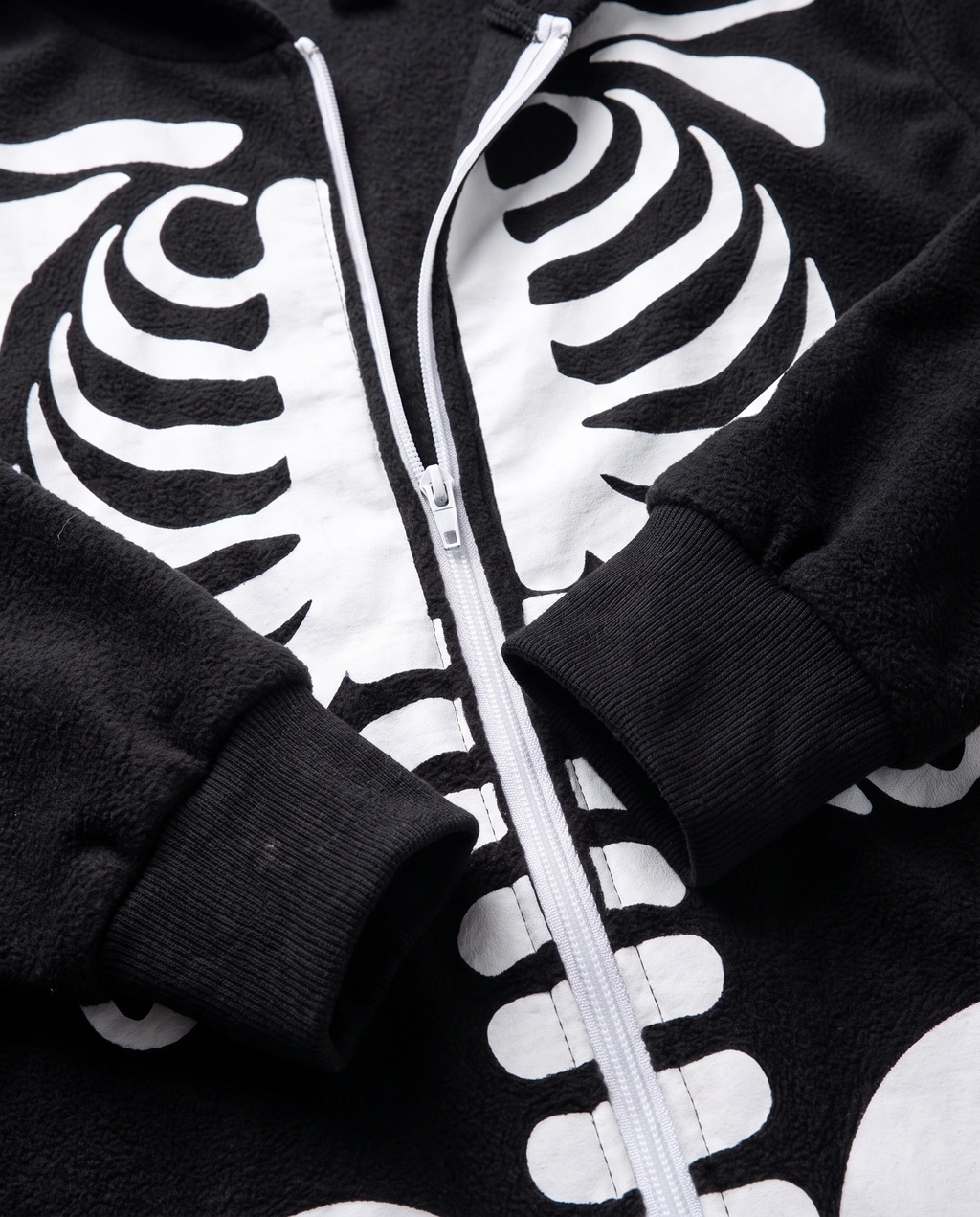 Detail of plush skeleton onesie zip and cuffs
